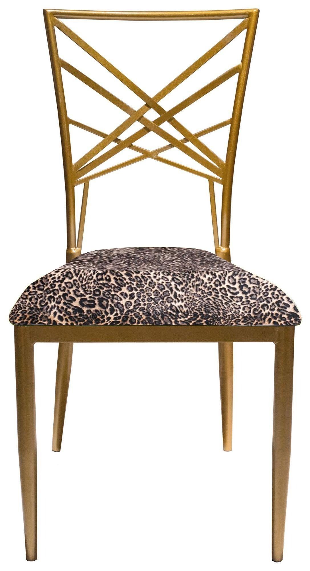 Gold lattice-back chair with a vibrant Leopard print velvet seat styled with matching accents and glossy tableware in a playful, luxurious setup.