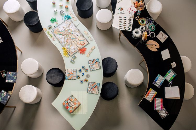 Black and white serpentine tables with velvet poufs