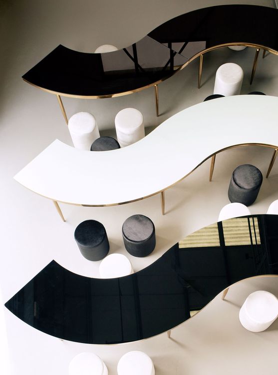 Black and white serpentine tables with velvet poufs