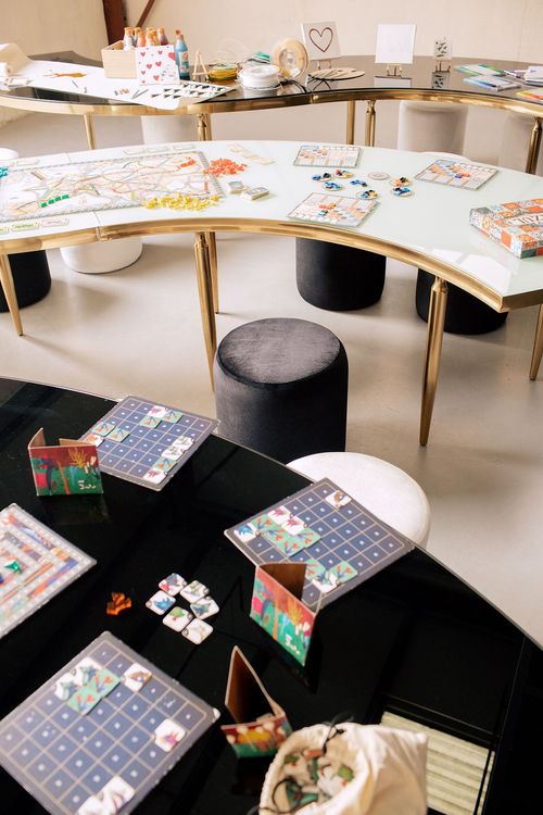 Black and white serpentine tables with velvet poufs