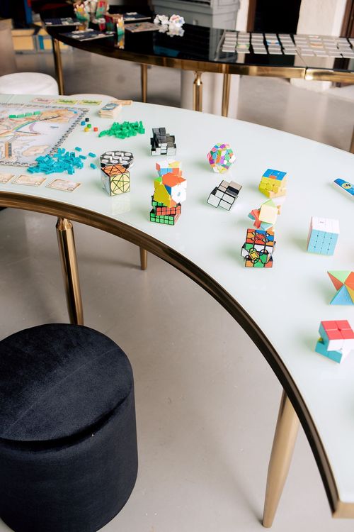 Black and white serpentine tables with velvet poufs