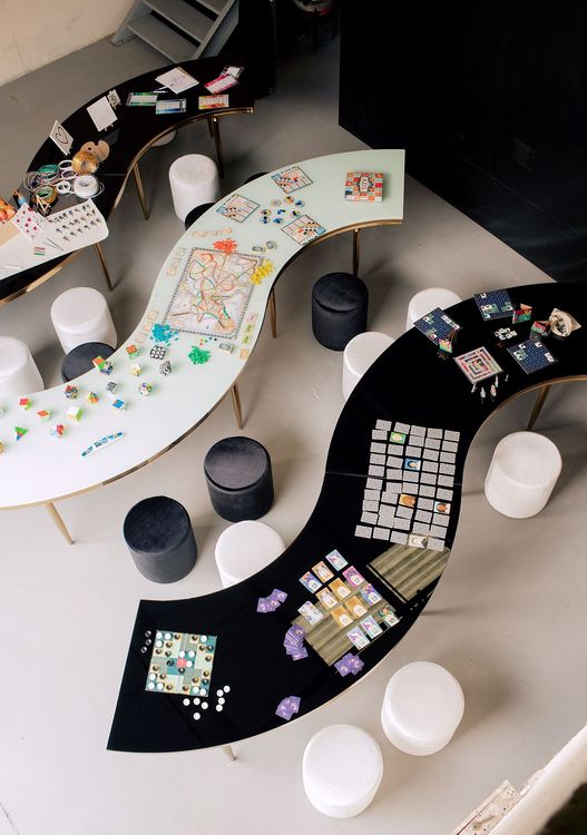 Black and white serpentine tables with velvet poufs