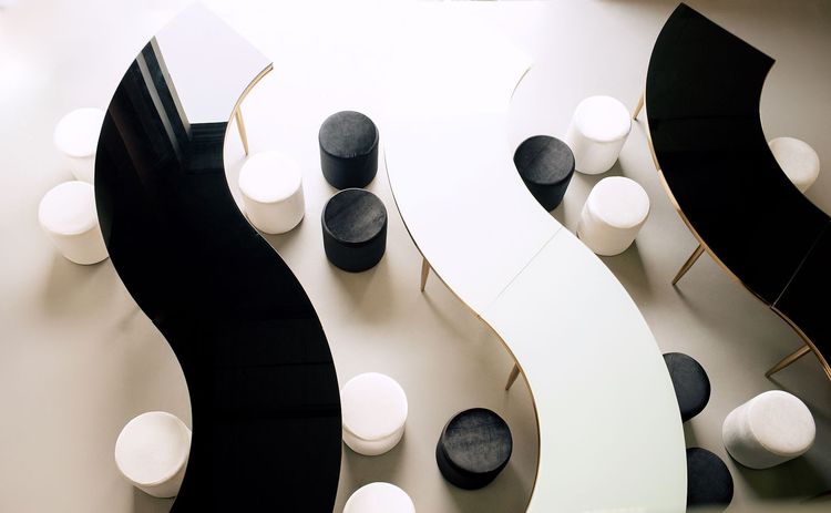 Black and white serpentine tables with velvet poufs