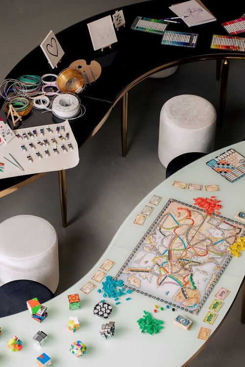 Black and white serpentine tables with velvet poufs