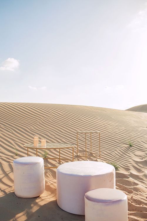 Pink desert lounge setup with ottomans