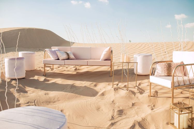 Pink desert lounge setup with ottomans