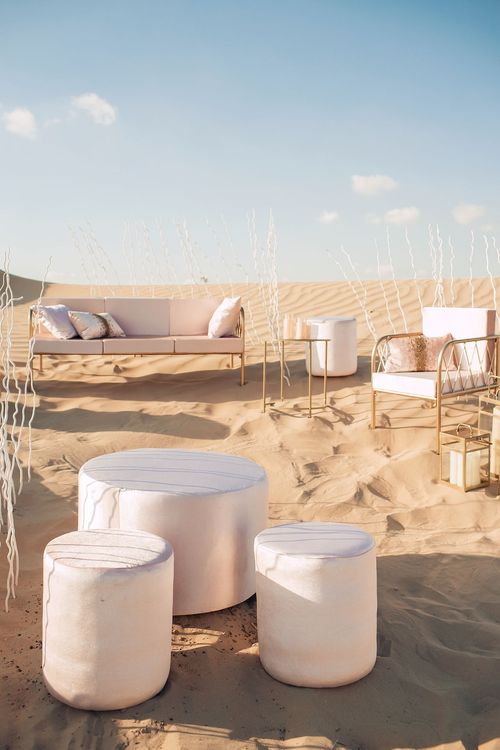 Pink desert lounge setup with ottomans