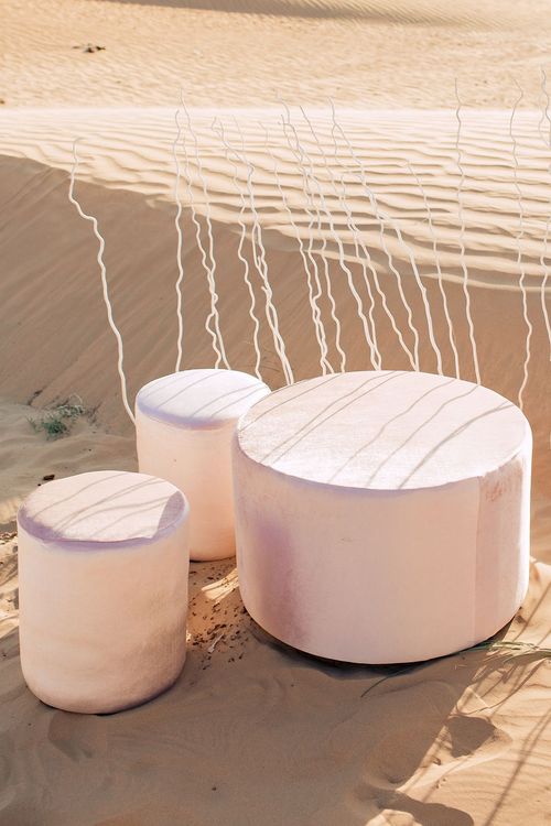 Pink desert lounge setup with ottomans