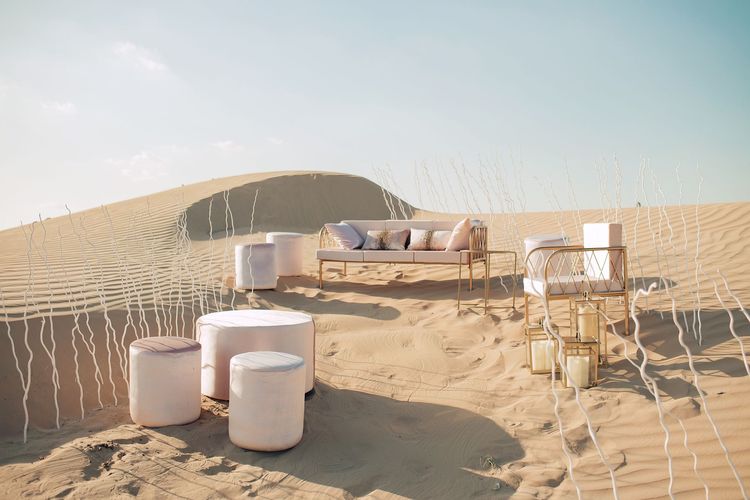 Pink desert lounge setup with ottomans
