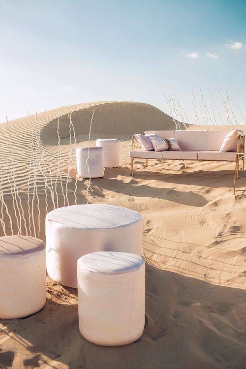 Pink desert lounge setup with ottomans