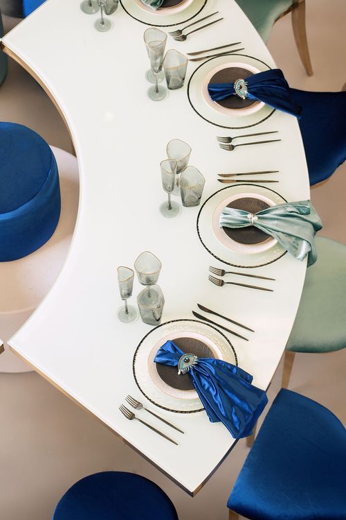 Eye-shaped table with a setup featuring blue accents