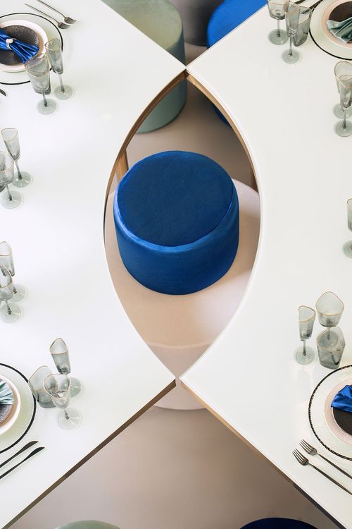 Eye-shaped table with a setup featuring blue accents