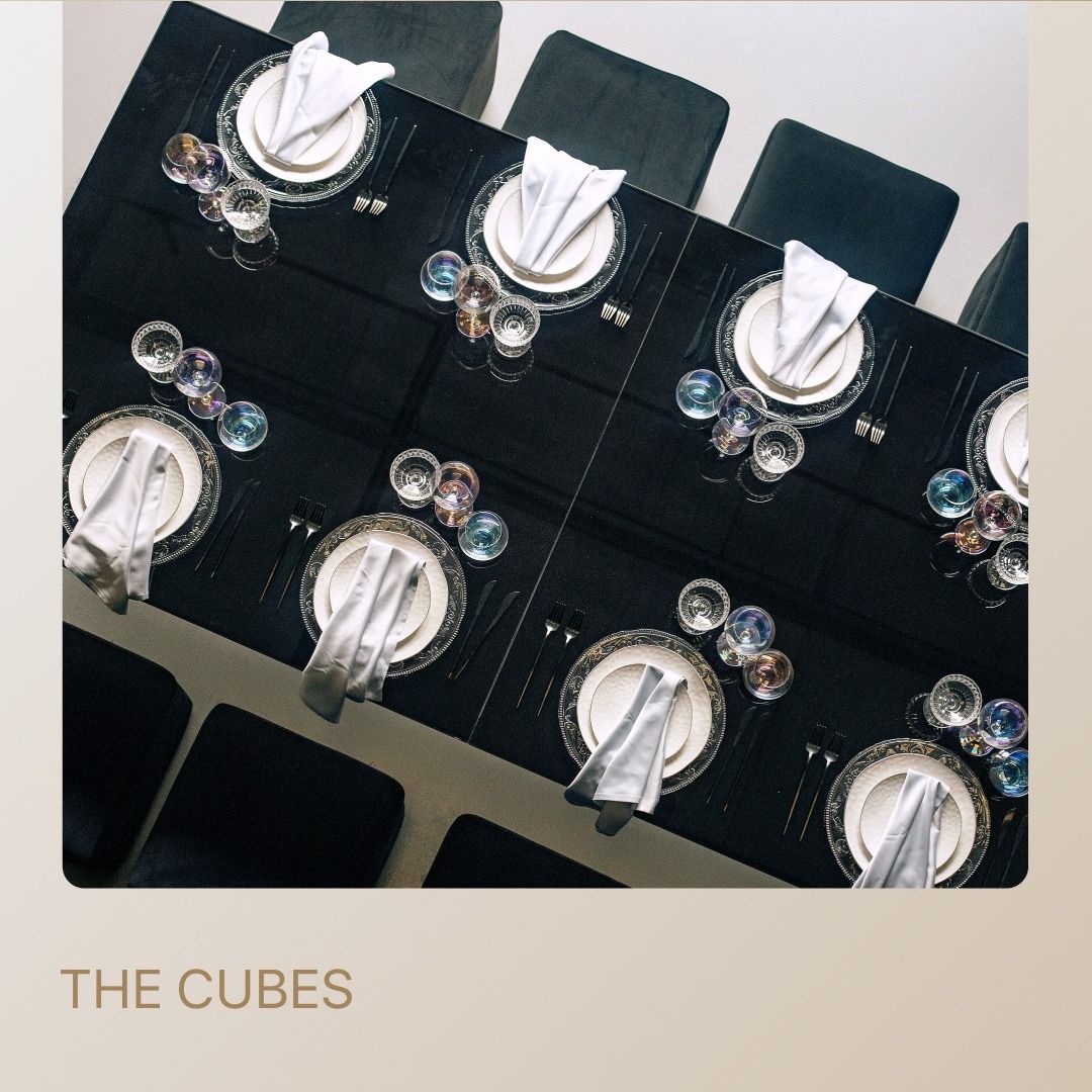 Minimalist black tablescape with square cube poufs — perfect for meetings or workshops.